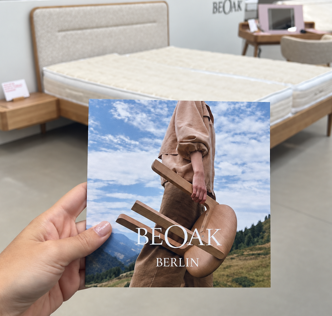 Gestapelte BeOak Kataloge und das Buch „A Place to Belong“ auf Eichentischen im Showroom Berlin