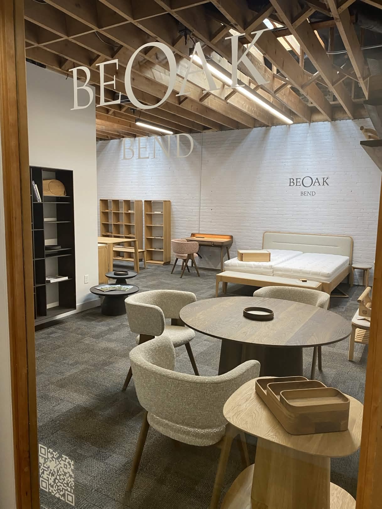 Eichenschreibtisch vor einer weißen Ziegelwand im BeOak Showroom in Bend, Oregon