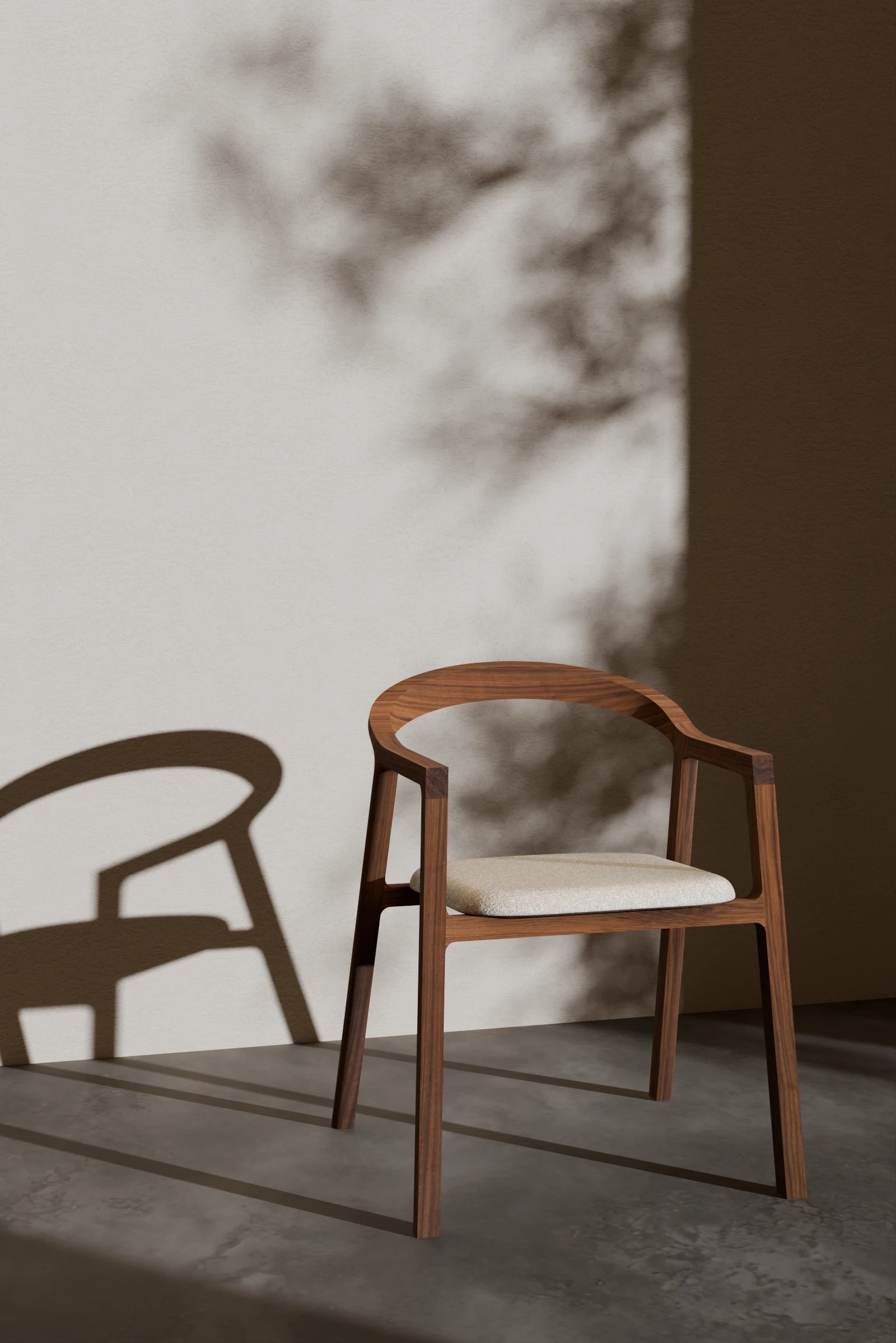 TUBA upholstered chair in solid walnut against a sunlit wall